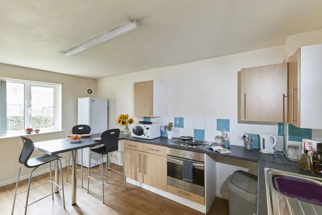 Table chairs fridge microwave oven and sink kitchen at 4 Bedroom House at 15, Brookside in Derby Student Accommodation