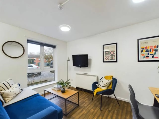 Blue sofa coffee table chair and TV living room at 4 Bedroom House at 17, Brookside in Derby Student Accommodation