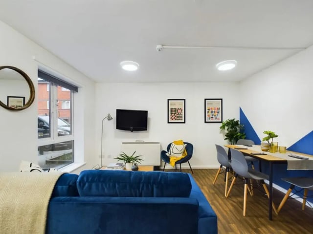 Blue sofa, dining table, chairs, television living room at 4 Bedroom House at 17, Brookside in Derby Student Accommodation