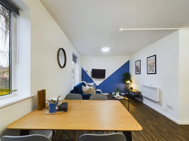 Table chairs sofa TV and heater living room at 3 Bedroom House at 20, Brookside in Derby Student Accommodation