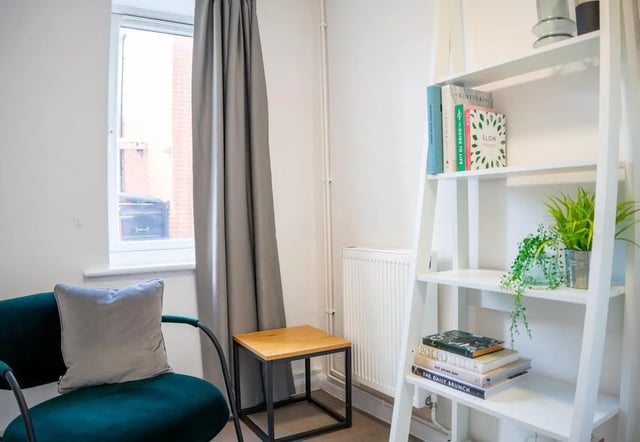 Chair side table shelf with books plants living room at 5 Bedroom House at 64C, Monson Street in Lincoln Student Accommodation