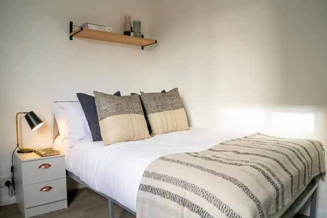 Bed with pillows lamp bedside table shelf Bedroom at 5 Bedroom House at 64C, Monson Street in Lincoln Student Accommodation