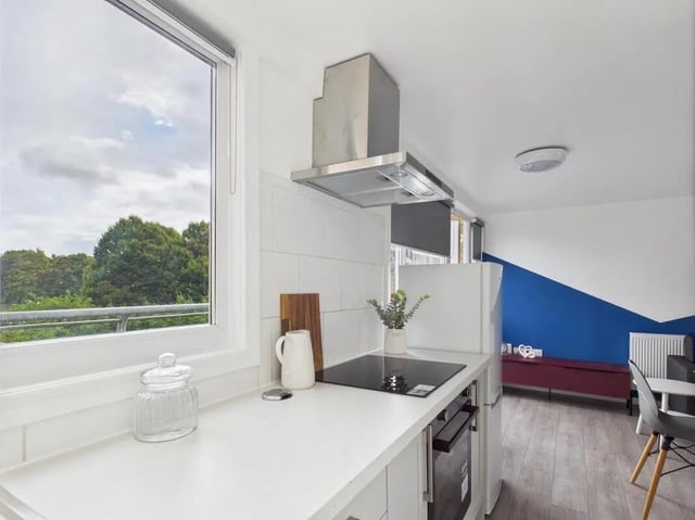 White countertop stove fridge and dining area kitchen at 1 Bedroom House at Flat 25, Grove Street Studios, The Groves in Liverpool Student Accommodation