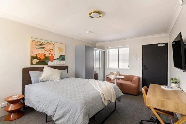 Bed wardrobe sofa desk with painting Bedroom at UKO Redfern in Sydney Student Accommodation