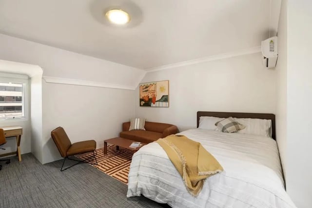 Bed sofa desk chair rug art bedroom at UKO Redfern in Sydney Student Accommodation