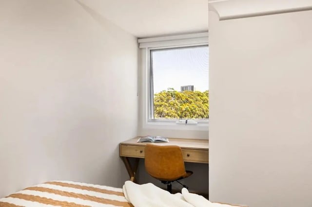 Desk with chair and book by window bedroom at UKO Redfern in Sydney Student Accommodation