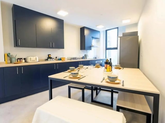 Dining table and chairs in communal kitchen kitchen at SEREN in Swansea Student Accommodation
