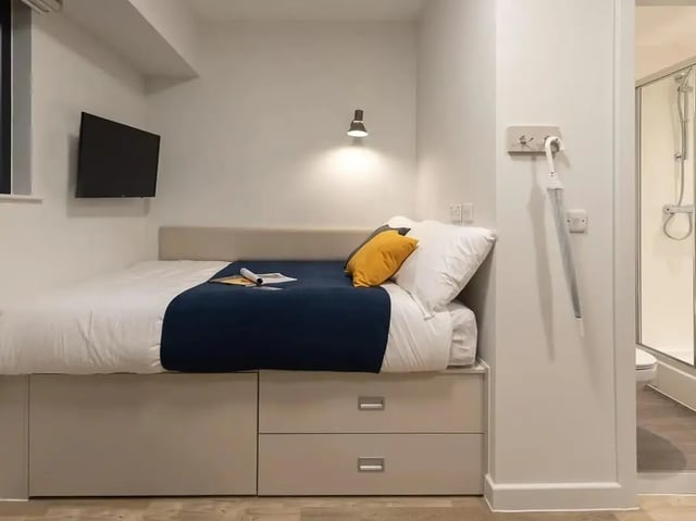 Bed with drawers TV umbrella shower stall bedroom at SEREN in Swansea Student Accommodation