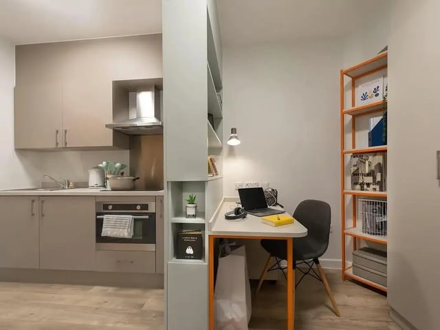 Kitchen and desk area with laptop and chair kitchen at SEREN in Swansea Student Accommodation
