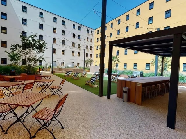 Courtyard with tables chairs and deckchairs exterior at SEREN in Swansea Student Accommodation