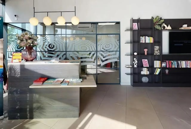 Reception desk with magazines and vase lounge at SEREN in Swansea Student Accommodation