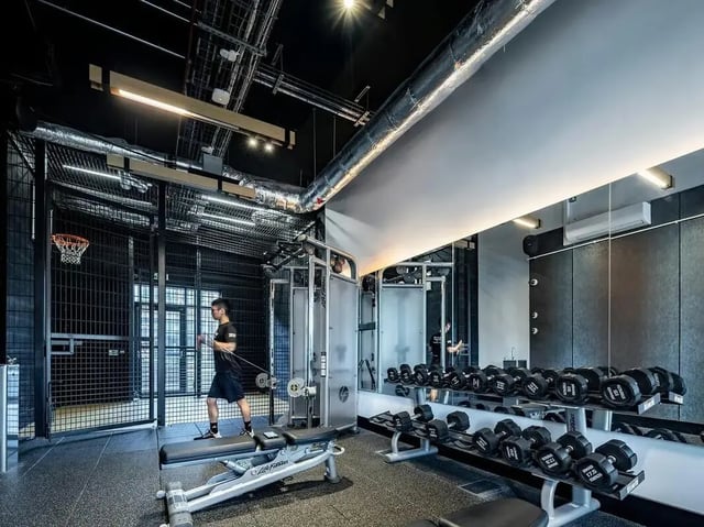 Man exercising weights dumbbells gym equipment gym at SEREN in Swansea Student Accommodation