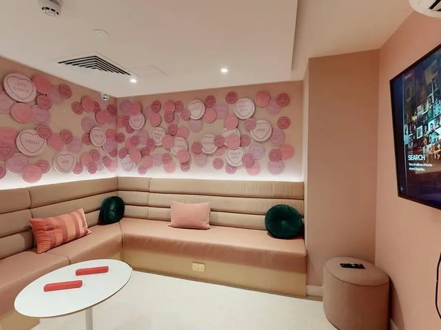 Pink heart decorations corner sofa and TV living room at SEREN in Swansea Student Accommodation