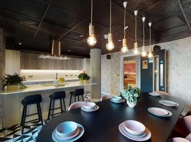 Modern kitchen island with stools and dining table area Kitchen at SEREN in Swansea Student Accommodation