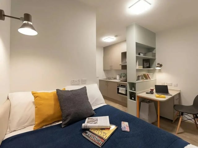 Bed with pillows kitchen study area living room at SEREN in Swansea Student Accommodation
