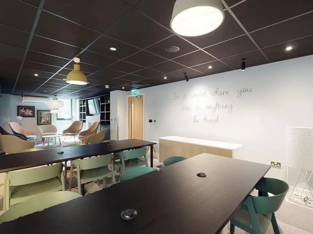 Modern communal area with tables chairs and seating. at SEREN in Swansea Student Accommodation