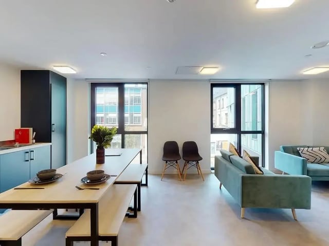 Dining table benches kitchen cabinets sofas living room at SEREN in Swansea Student Accommodation