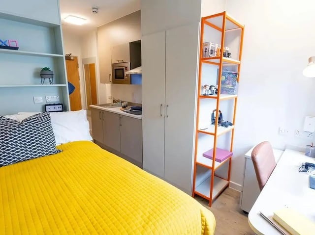 Bed kitchen storage desk and shelves student room at SEREN in Swansea Student Accommodation