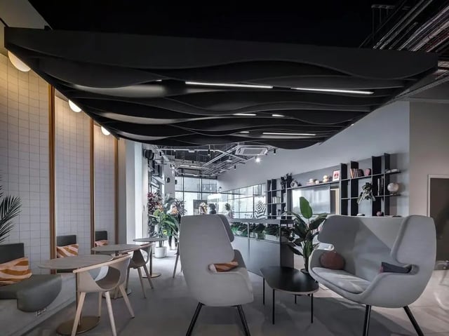 Modern lounge area with couches and tables communal area at SEREN in Swansea Student Accommodation