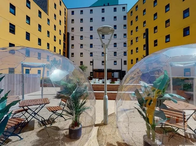 Clear domes, tables, chairs, plants, exterior at SEREN in Swansea Student Accommodation