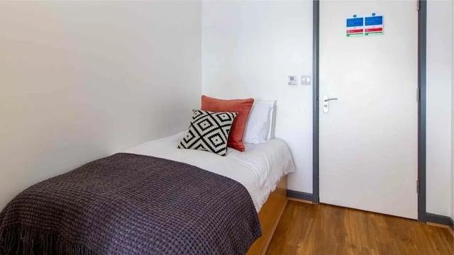 Single bed with patterned pillows and throw bedroom at Alexandra Hall in Aberystwyth Student Accommodation