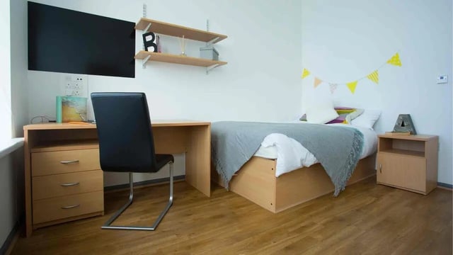 Desk bed nightstand and television bedroom at Alexandra Hall in Aberystwyth Student Accommodation