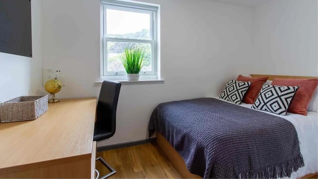 Desk chair globe basket bed pillows window bedroom at Alexandra Hall in Aberystwyth Student Accommodation