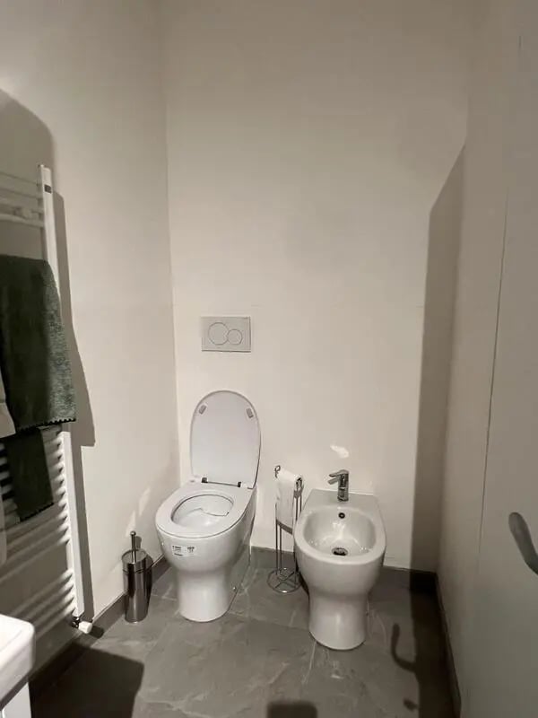Toilet bidet toilet brush towel rack bathroom at Entire Apartment In Tapigliano Near Lago Maggiore in Tapigliano Student Accommodation