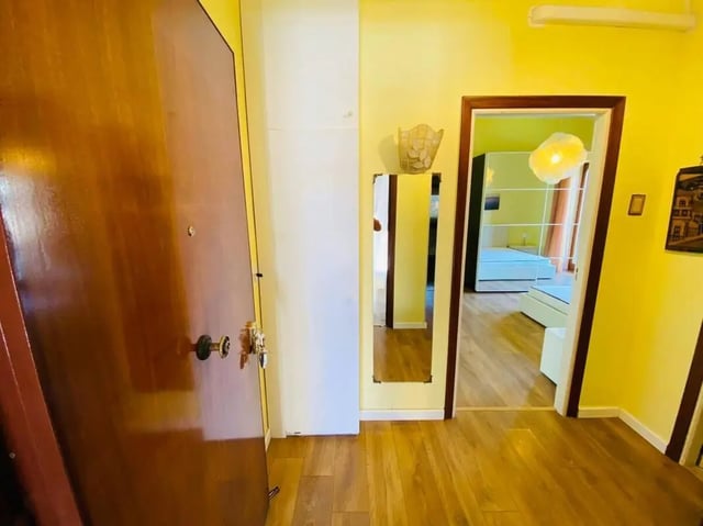 Wooden door mirror and white closet hallway bedroom at Appartamento soleggiato con ampia terrazza, giardino e parcheggio in Sant'Agnello Student Accommodation