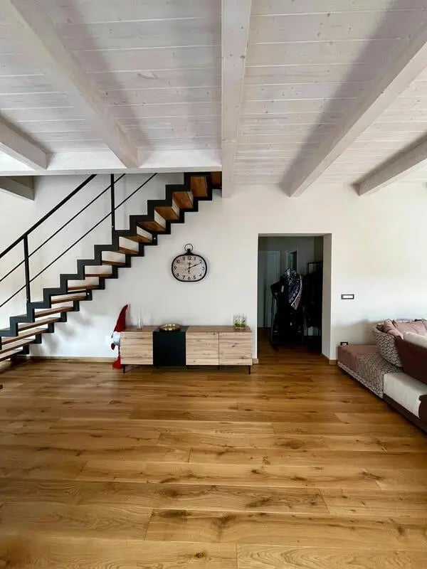 Wooden floor staircase modern sideboard clock living room at Welcoming double ensuite bedroom near the Vezzano Ligure train station in La Spezia Student Accommodation