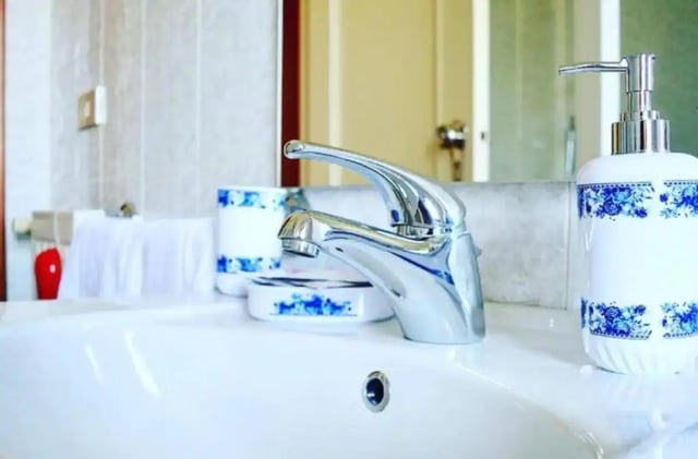 Sink soap dispenser and faucet bathroom at Appartamento soleggiato con ampia terrazza, giardino e parcheggio in Sant'Agnello Student Accommodation