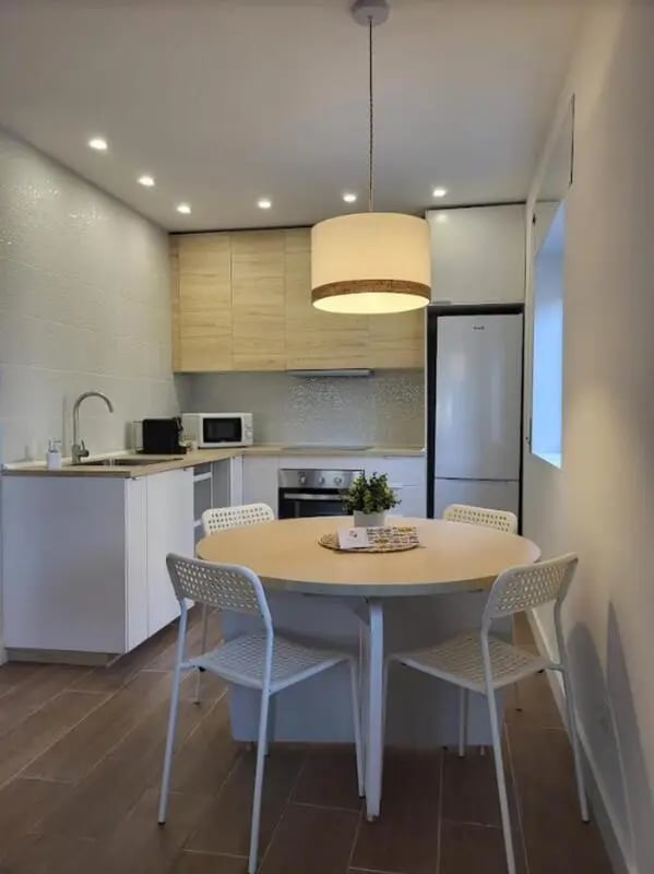 Round table with chairs and kitchen amenities kitchen at Welcoming 2-bedroom apartment in Fundão in Fundão Student Accommodation