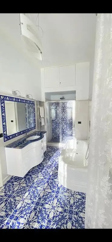 White sink shower and bathtub with blue tiles Bathroom at Appartamento di due stanze in Sant'Agnello Student Accommodation