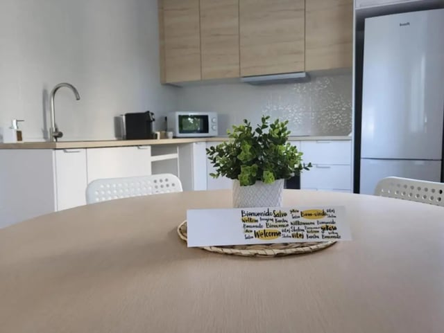 Kitchen table with welcome sign and plants kitchen at Welcoming 2-bedroom apartment in Fundão in Fundão Student Accommodation