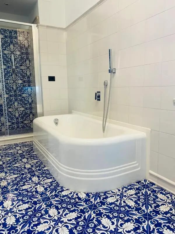 White bathtub patterned blue floor shower Bathroom at Appartamento di due stanze in Sant'Agnello Student Accommodation