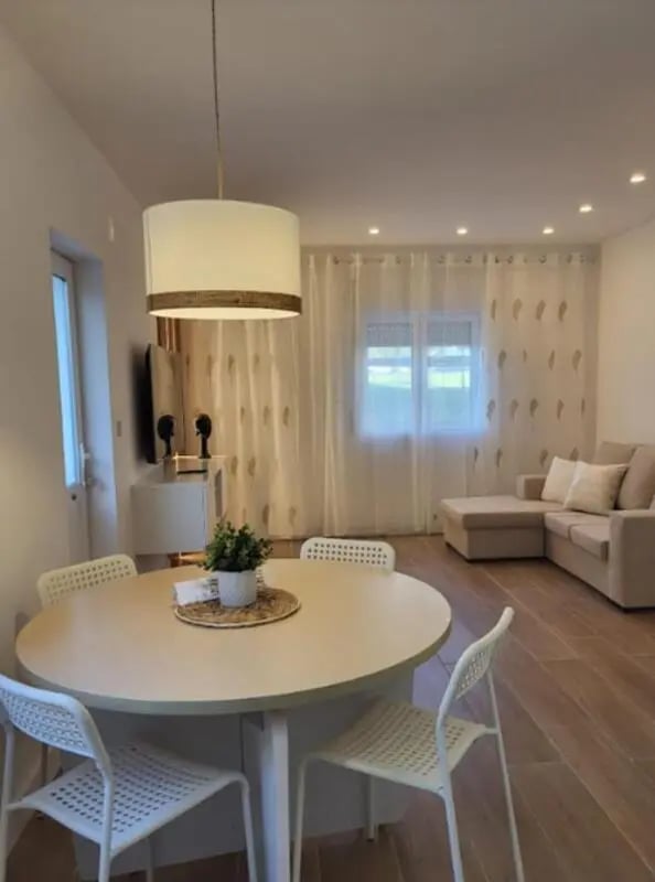 Round dining table four chairs sectional sofa living room at Welcoming 2-bedroom apartment in Fundão in Fundão Student Accommodation