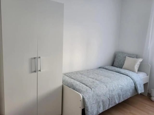 White wardrobe and patterned bed bedroom at Welcoming 2-bedroom apartment in Fundão in Fundão Student Accommodation