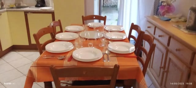 Table set with plates chairs kitchen dining area at 2-bedroom house, with outdoor area in La Spezia Student Accommodation