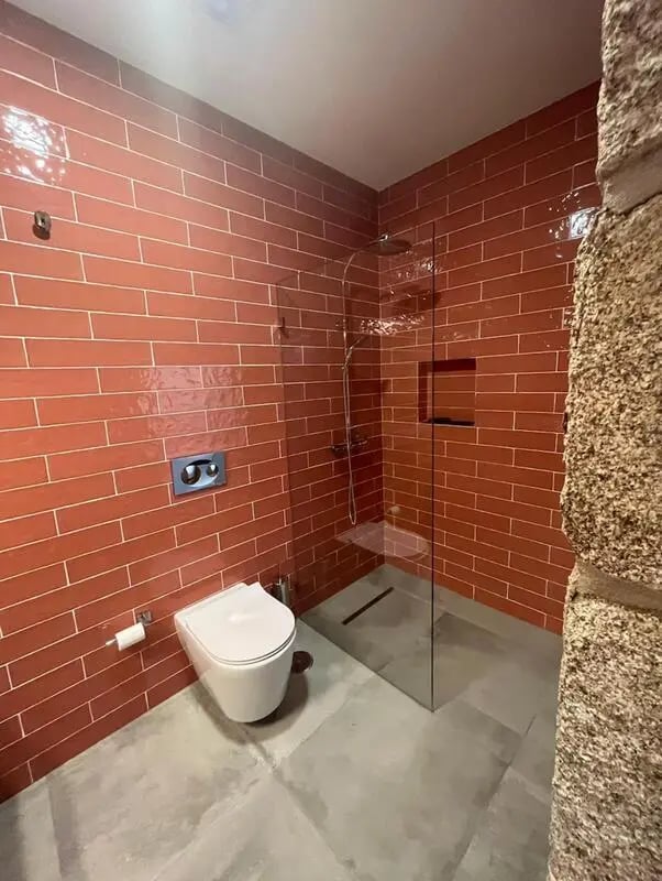 Toilet and glass shower with red brick wall bathroom at Spacious Double Bedroom ensuite close to Barragem de Vascoveiro in Guarda Student Accommodation