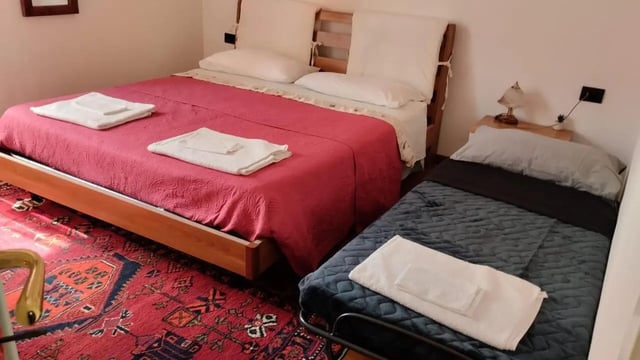 Two beds and a rug bedroom at 2-bedroom house, with outdoor area in La Spezia Student Accommodation