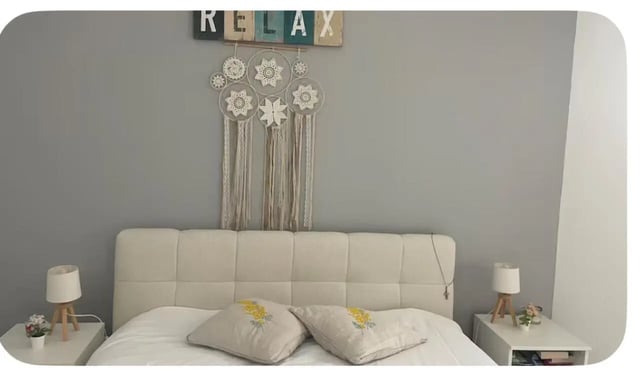 Bed with decorative wall hanging and lamps bedroom at 1-bedroom flat in Armação de Pêra with balcony all electric no Gas in Silves Student Accommodation