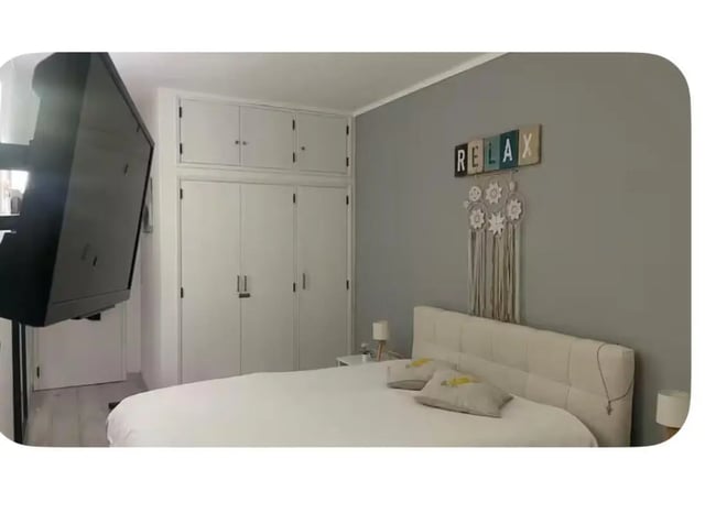 Flat screen television and large white wardrobe bedroom at 1-bedroom flat in Armação de Pêra with balcony all electric no Gas in Silves Student Accommodation