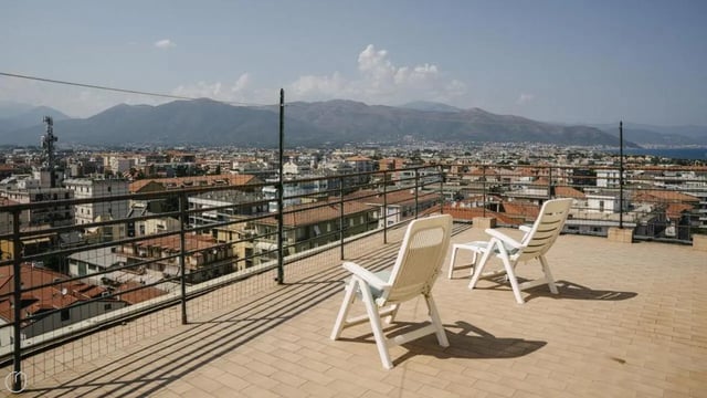 Two white chairs on tiled roof overlooking city exterior at Welcoming 2-bedroom apartment near the Albenga train station in Albenga Student Accommodation