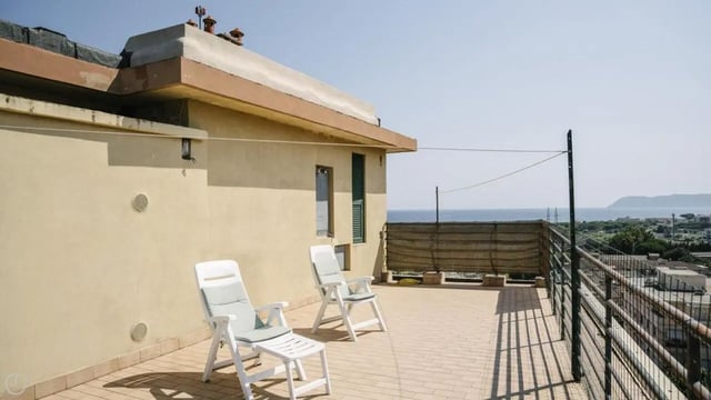 Two white chairs on tiled balcony exterior at Welcoming 2-bedroom apartment near the Albenga train station in Albenga Student Accommodation