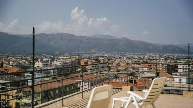 Two white loungers overlooking city exterior at Welcoming 2-bedroom apartment near the Albenga train station in Albenga Student Accommodation
