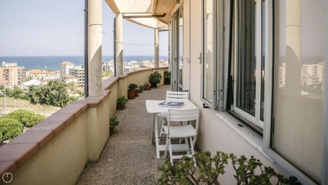 Balcony with table chairs and potted plants exterior at Welcoming 2-bedroom apartment near the Albenga train station in Albenga Student Accommodation