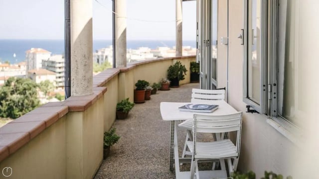 Balcony with table chairs and potted plants exterior at Welcoming 2-bedroom apartment near the Albenga train station in Albenga Student Accommodation