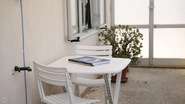 White table chairs and a plant exterior at Welcoming 2-bedroom apartment near the Albenga train station in Albenga Student Accommodation