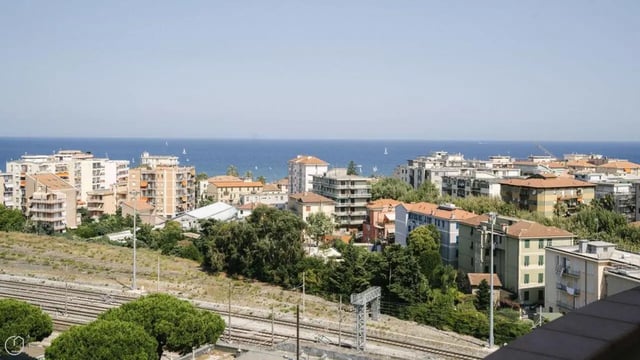 Buildings near the ocean with railway tracks exterior at Welcoming 2-bedroom apartment near the Albenga train station in Albenga Student Accommodation