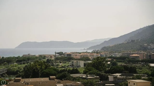Coastal town with mountains and ocean exterior at Welcoming 2-bedroom apartment near the Albenga train station in Albenga Student Accommodation